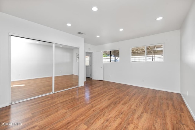 unfurnished bedroom featuring a closet and hardwood / wood-style floors