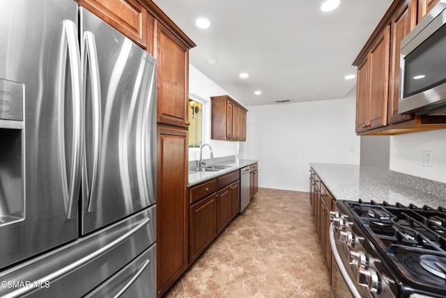 kitchen with sink, light stone counters, and stainless steel appliances