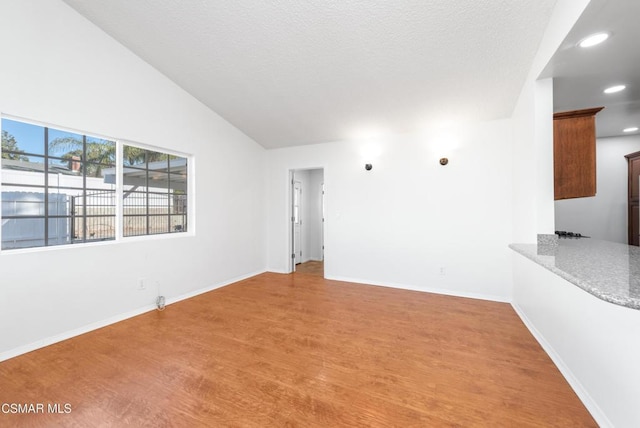 empty room with hardwood / wood-style flooring and high vaulted ceiling