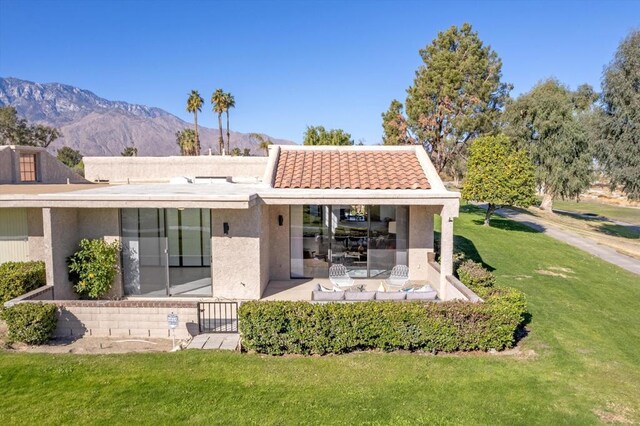 rear view of property with a mountain view and a yard