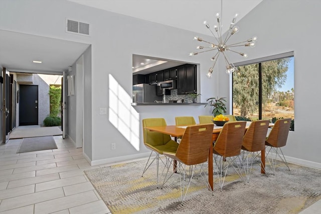 tiled dining area featuring an inviting chandelier and vaulted ceiling