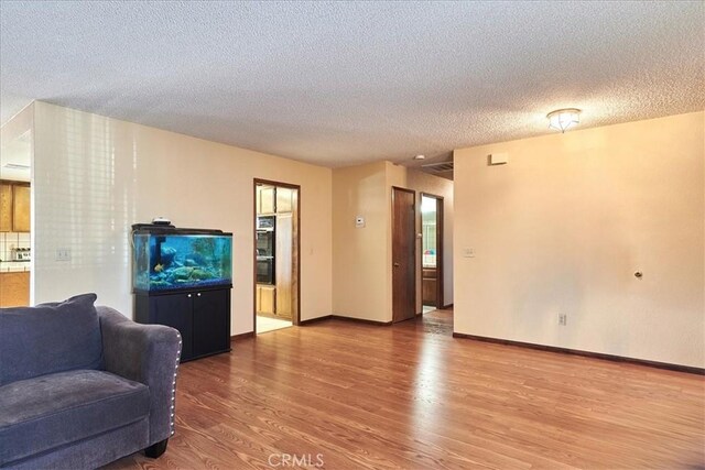 living room with hardwood / wood-style flooring and a textured ceiling