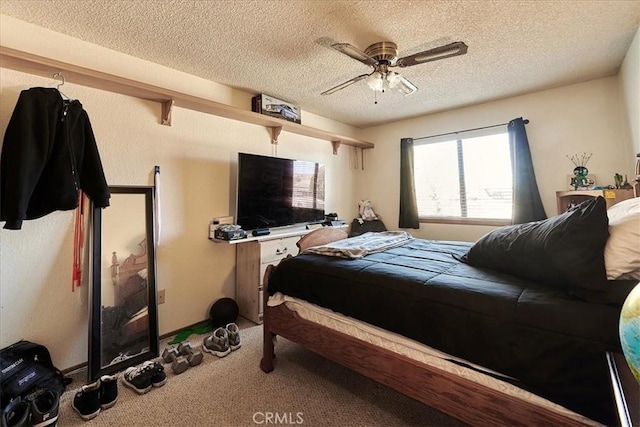 carpeted bedroom with ceiling fan and a textured ceiling