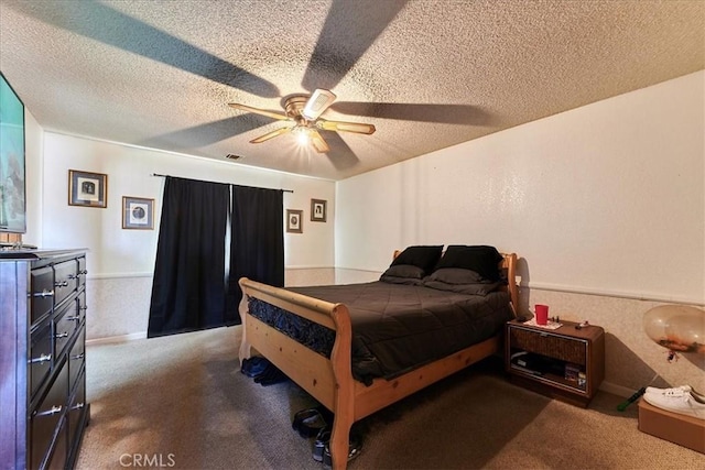 carpeted bedroom featuring ceiling fan and a textured ceiling