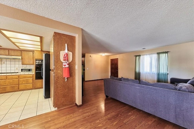 living room with light hardwood / wood-style floors and a textured ceiling