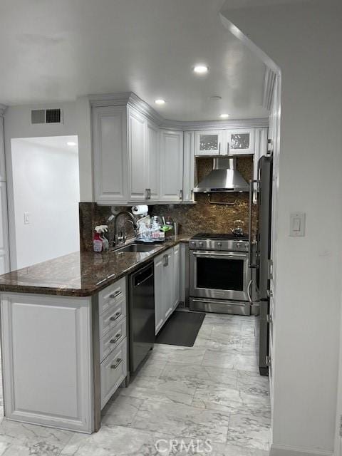 kitchen with gas stove, black dishwasher, dark stone counters, sink, and backsplash