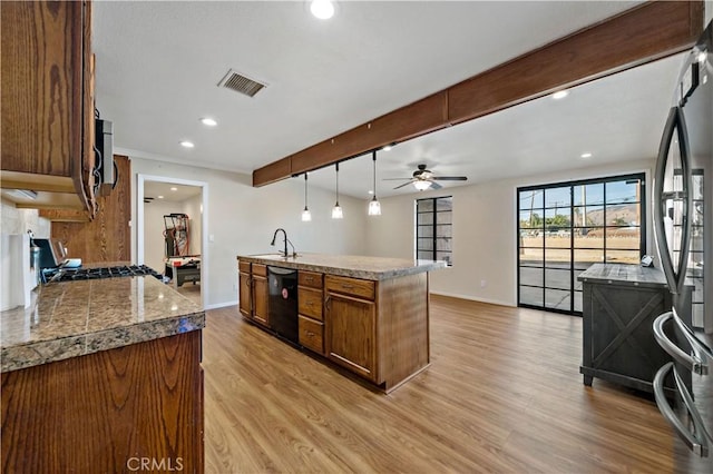 kitchen featuring light hardwood / wood-style floors, dishwasher, stove, sink, and pendant lighting