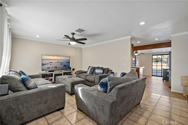 tiled living room with ceiling fan and ornamental molding