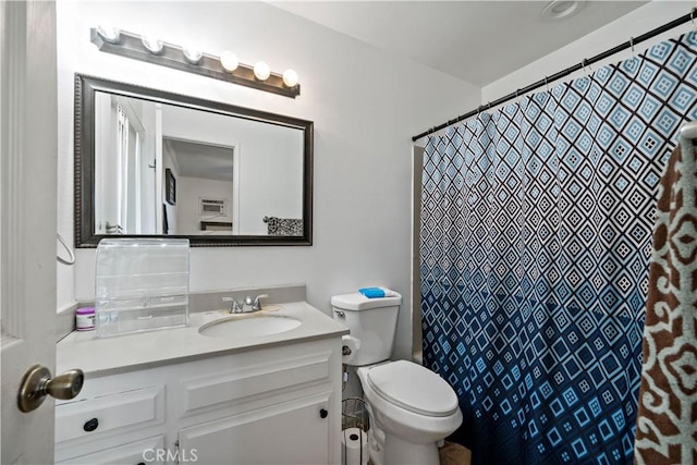 bathroom with toilet, a shower with shower curtain, and vanity