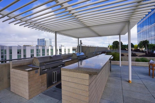 view of patio / terrace with grilling area, a pergola, and an outdoor kitchen