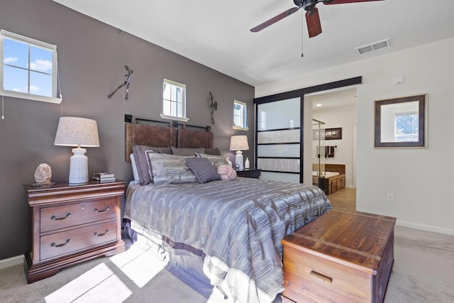 carpeted bedroom featuring ensuite bath and ceiling fan