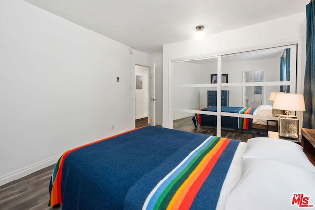 bedroom with a closet and dark wood-type flooring