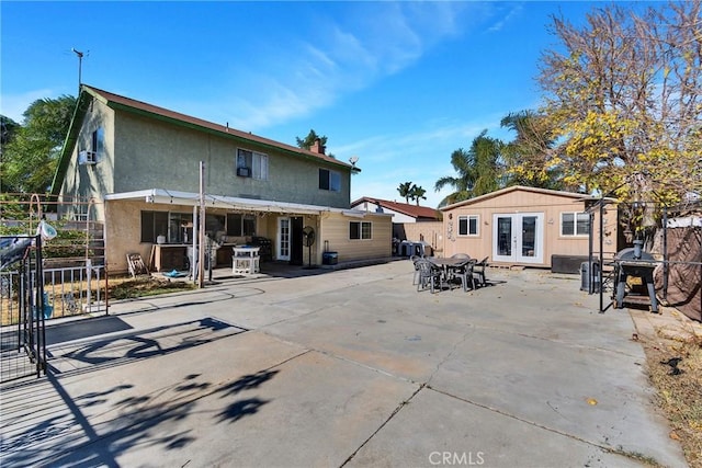 back of property with a patio area, french doors, and an outdoor structure