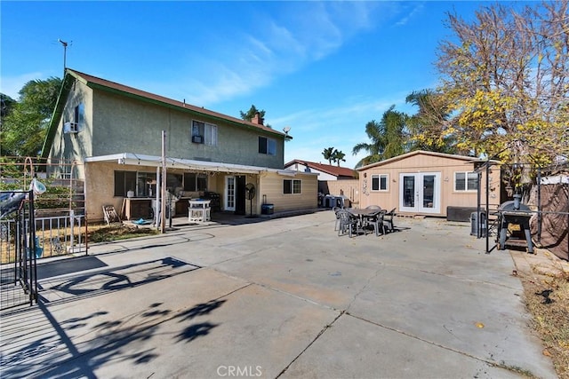 rear view of house with a patio, french doors, fence, and an outdoor structure