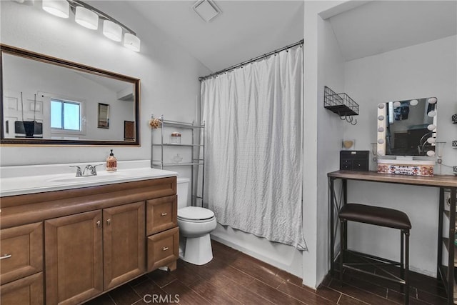 bathroom with wood finish floors, vanity, visible vents, toilet, and lofted ceiling