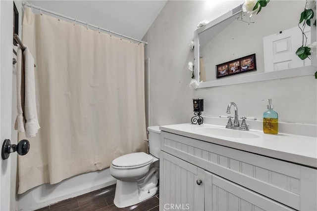 bathroom featuring toilet, vanity, and vaulted ceiling