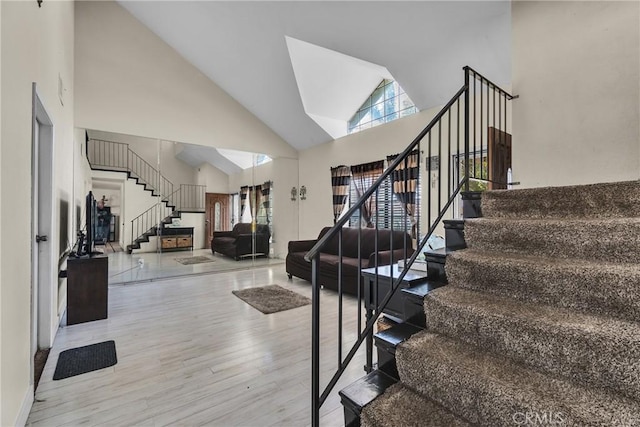 staircase with wood-type flooring and a high ceiling