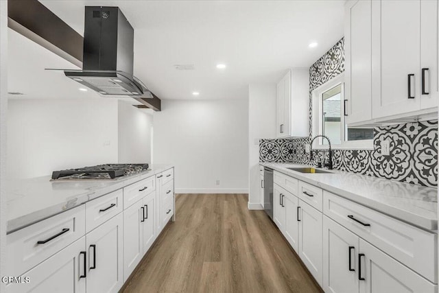 kitchen with white cabinetry, stainless steel appliances, light hardwood / wood-style floors, sink, and ventilation hood