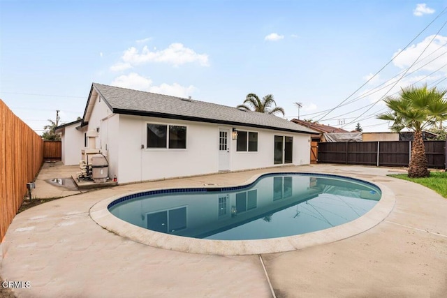 rear view of house featuring a patio and a fenced in pool