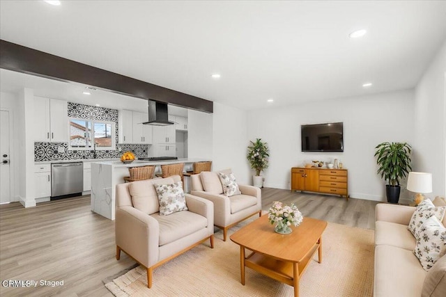 living room featuring beam ceiling and light wood-type flooring