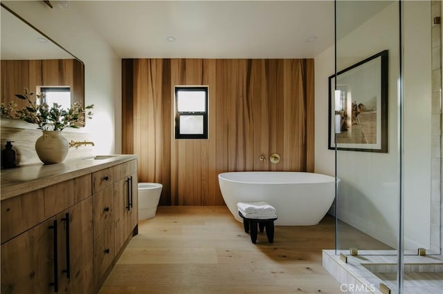 full bathroom featuring hardwood / wood-style floors, toilet, vanity, and shower with separate bathtub