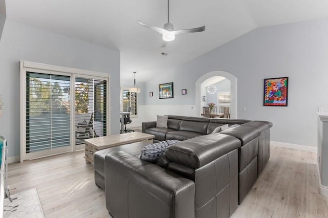 living room with ceiling fan, light wood-type flooring, and lofted ceiling