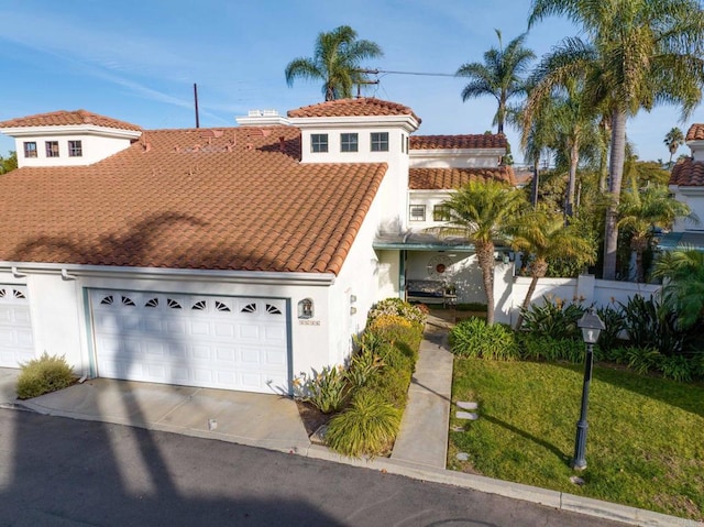 mediterranean / spanish house with a garage and a front yard