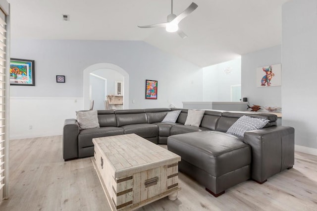 living room featuring ceiling fan, light hardwood / wood-style floors, and lofted ceiling