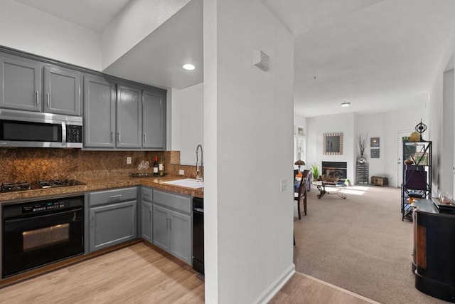 kitchen featuring backsplash, gray cabinets, sink, and black appliances