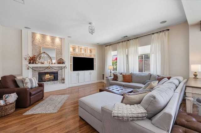 living room with built in features and hardwood / wood-style flooring