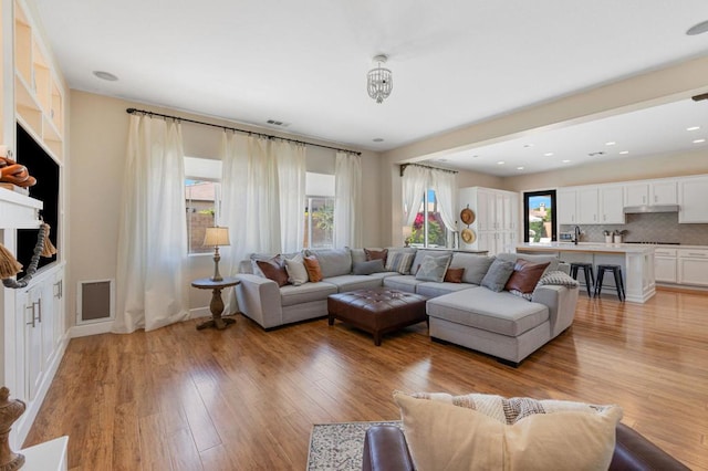 living room featuring light wood-type flooring and plenty of natural light