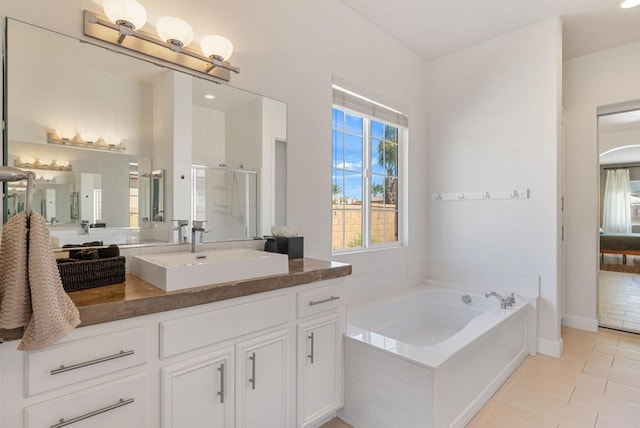 bathroom with tile patterned floors, separate shower and tub, and vanity