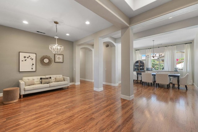 living room with wood-type flooring and a notable chandelier