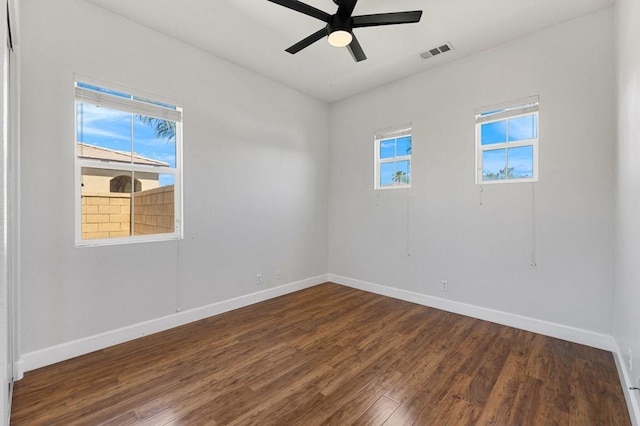 empty room with ceiling fan and dark hardwood / wood-style flooring