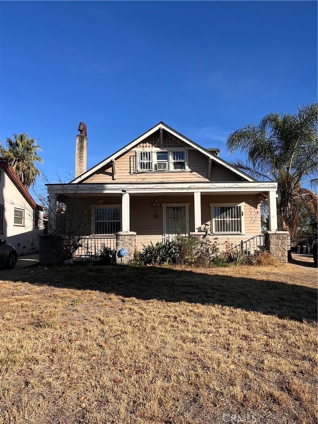 craftsman-style house with a front lawn and covered porch