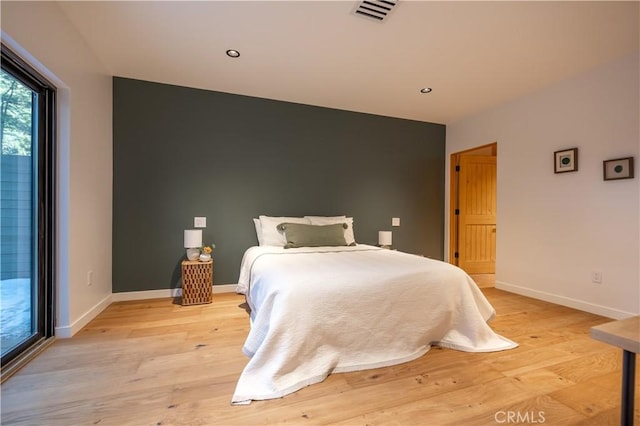 bedroom featuring light wood-type flooring, visible vents, baseboards, and recessed lighting