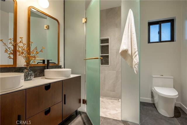 bathroom featuring toilet, vanity, tile patterned flooring, and walk in shower