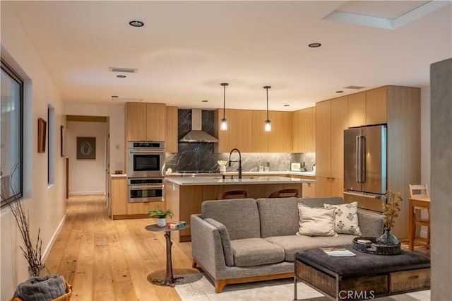 living room with visible vents, baseboards, and light wood-style floors