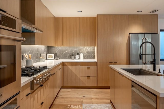 kitchen with light brown cabinets, appliances with stainless steel finishes, modern cabinets, and a sink