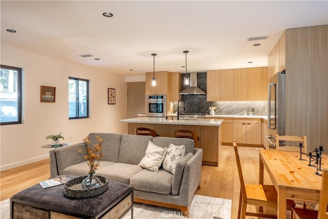 living room with sink and light wood-type flooring