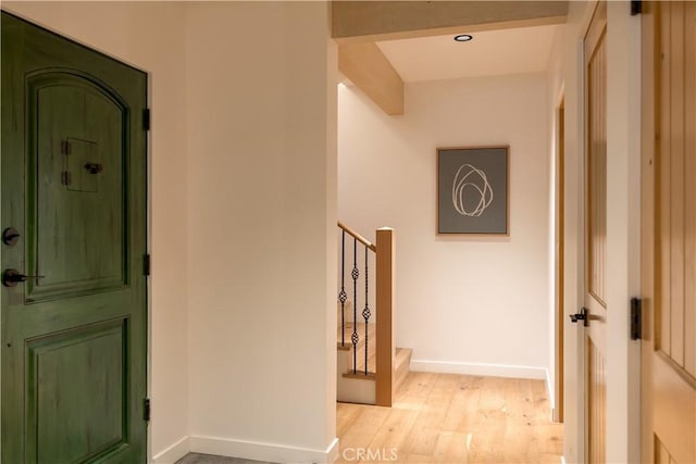 hallway with stairs, baseboards, and light wood finished floors