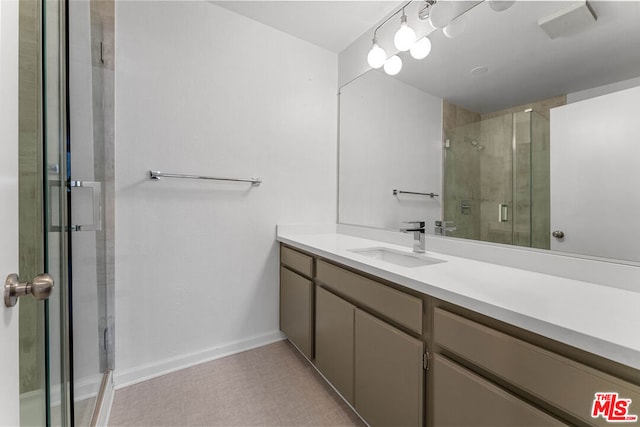 bathroom featuring vanity and a shower with door