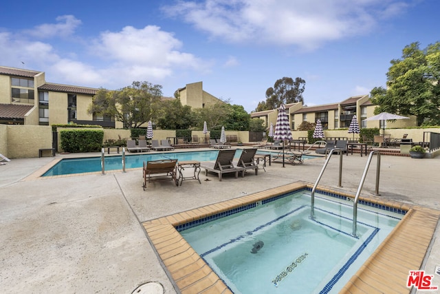 view of pool with a patio area and a hot tub