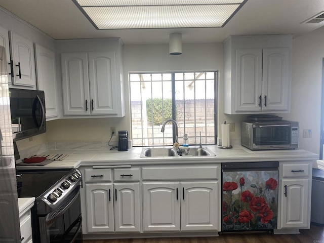 kitchen with black appliances, white cabinets, and sink