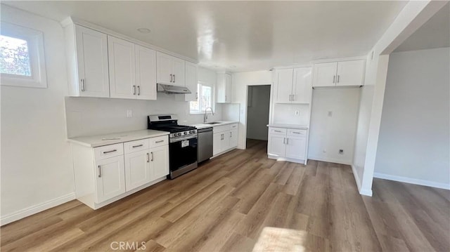 kitchen featuring light hardwood / wood-style floors, sink, white cabinetry, and appliances with stainless steel finishes