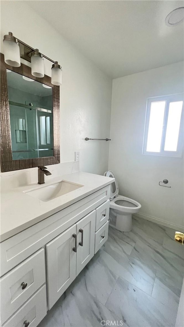 bathroom with toilet, vanity, and walk in shower