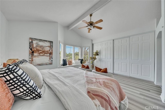 bedroom with ceiling fan, light hardwood / wood-style flooring, and lofted ceiling with beams