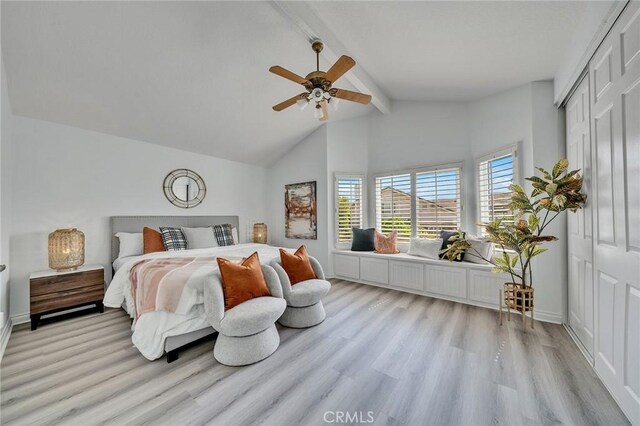 bedroom with light wood-type flooring, ceiling fan, and lofted ceiling with beams