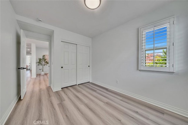 unfurnished bedroom with a closet and light hardwood / wood-style flooring