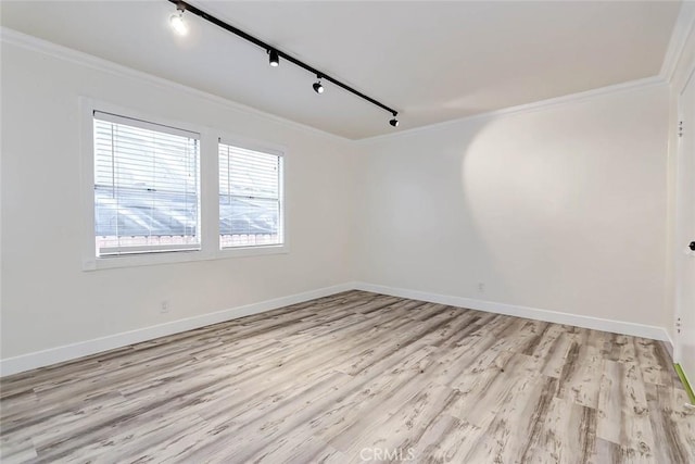 unfurnished room featuring crown molding, rail lighting, and light hardwood / wood-style flooring